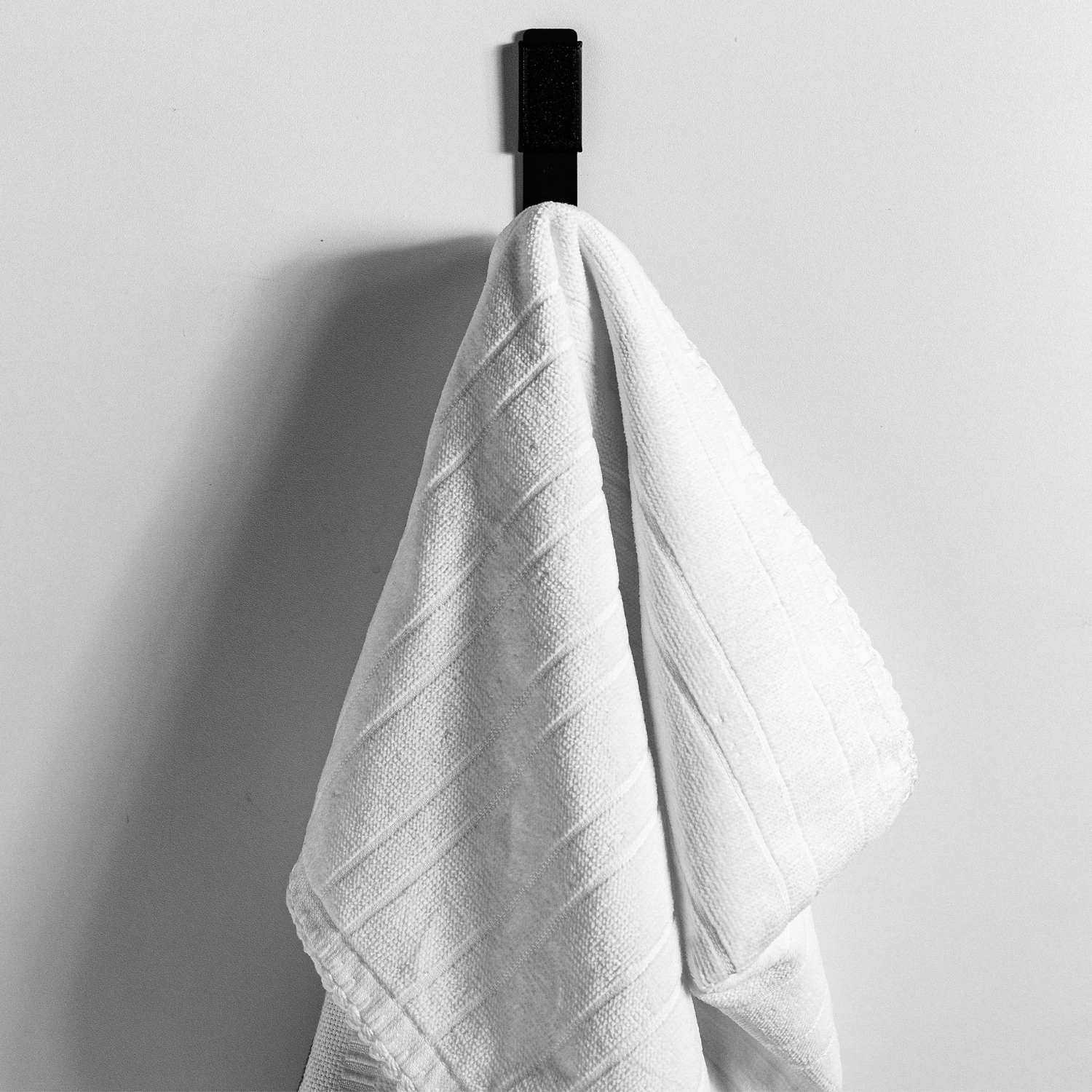 gancho preto de parede com toalha